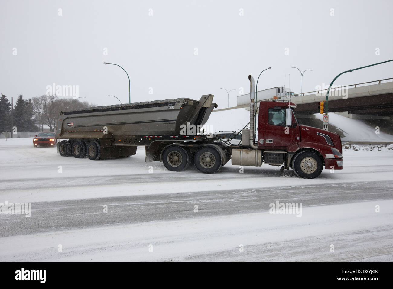 Grand camion de transport de charge de remorquage sur route gelée dans la neige qui tombe Saskatoon Saskatchewan Canada Banque D'Images
