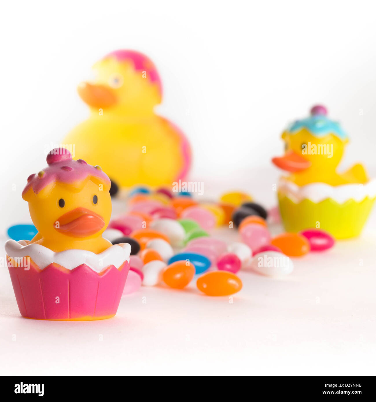 Canards en caoutchouc avec Pâques bonbons haricots colorés isolé sur fond blanc Banque D'Images