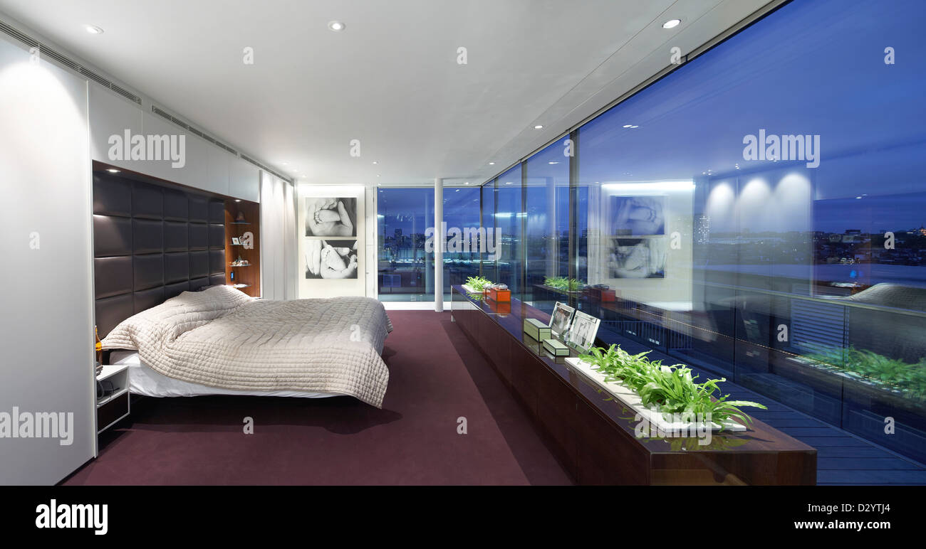 Ambika House, Londres, Royaume-Uni. Architecte : Buckley Gray Yeoman, 2011. Chambre de maître avec vitrage et vue de la ville au crépuscule Banque D'Images