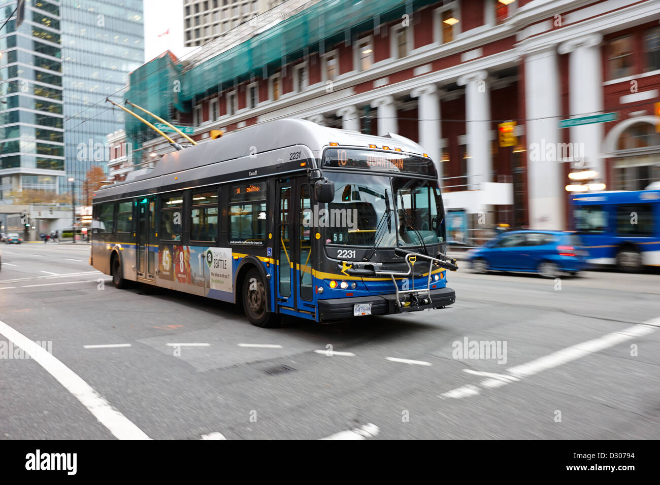 Electric bus speeding passé waterfront station au centre-ville de Vancouver, BC Canada Banque D'Images