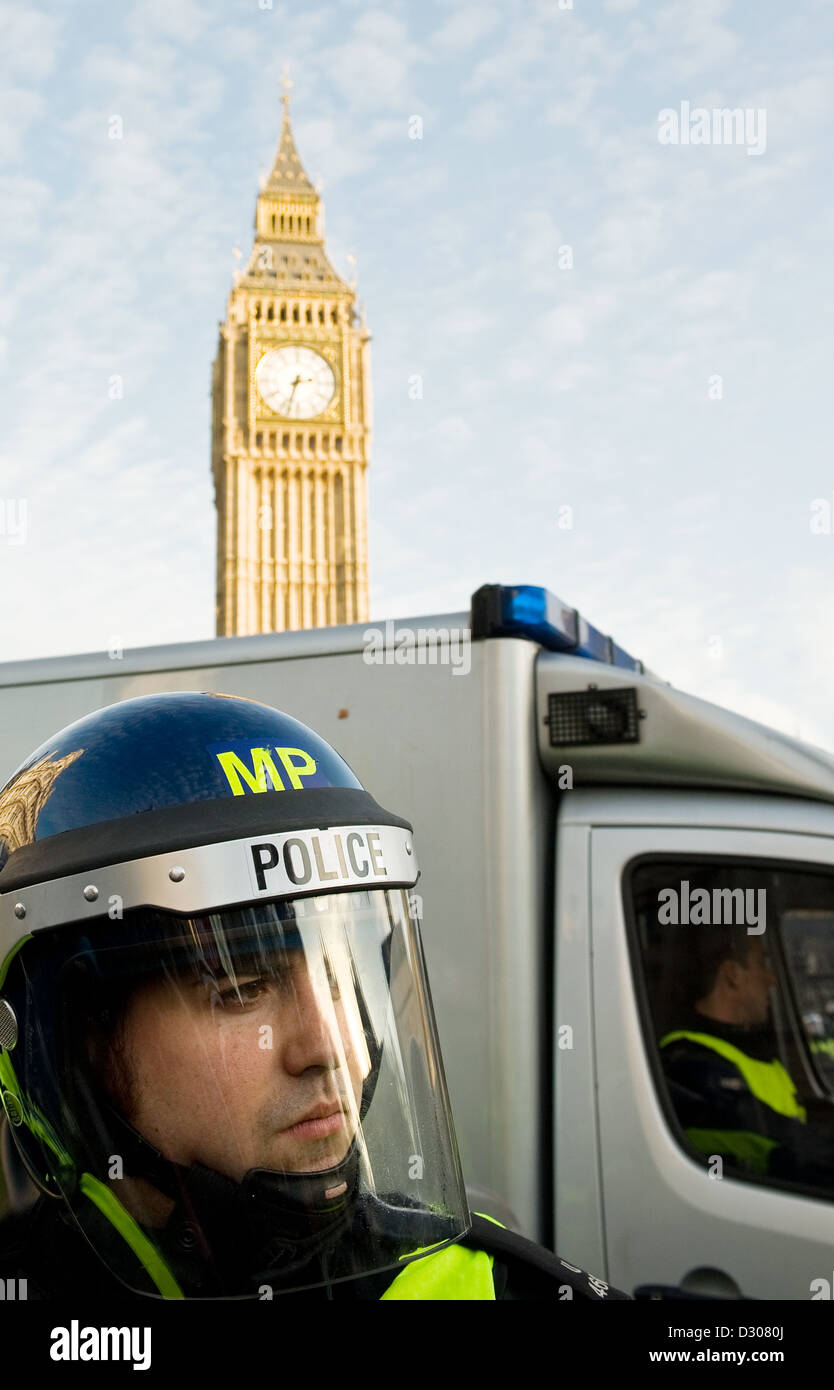 Officier de police dans une émeute de démonstration casque manifestation à Londres, UK avec Big Ben derrière Banque D'Images