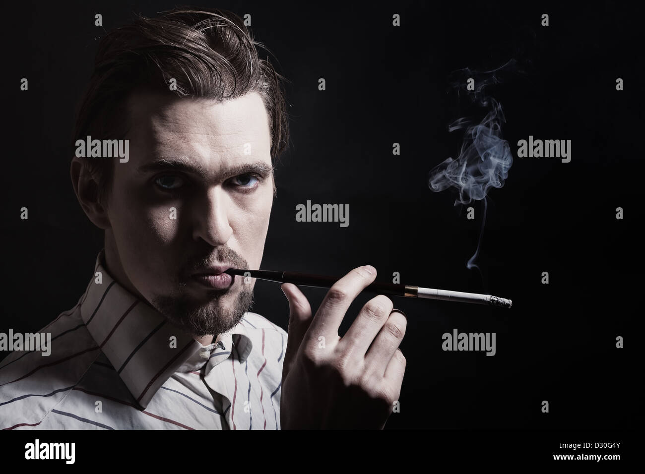 Portrait of young man smoking cigarette sur un fond noir. Style Retor Banque D'Images