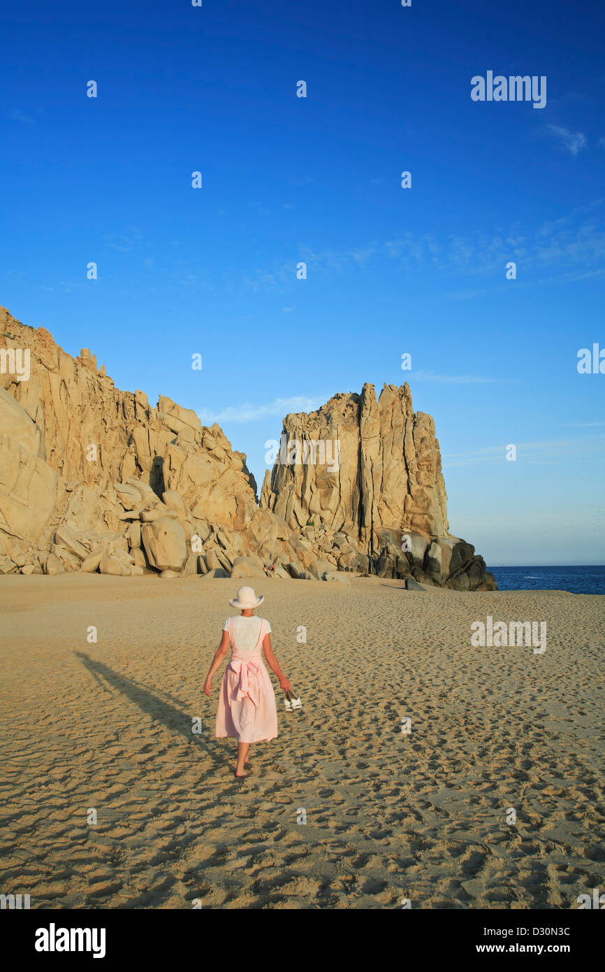 Femme marche sur le sable et roche de granit falaise à Land's End, Solmar Beach, Cabo San Lucas, Baja California Sur, Mexique Banque D'Images
