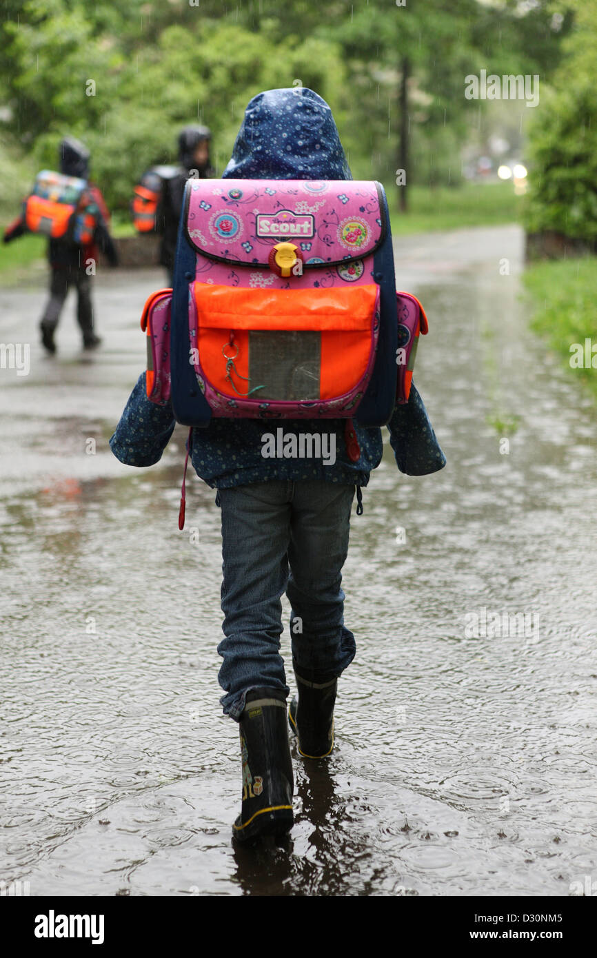 Berlin, Allemagne, un enfant fait sur le chemin de l'école par une flaque d'eau Banque D'Images