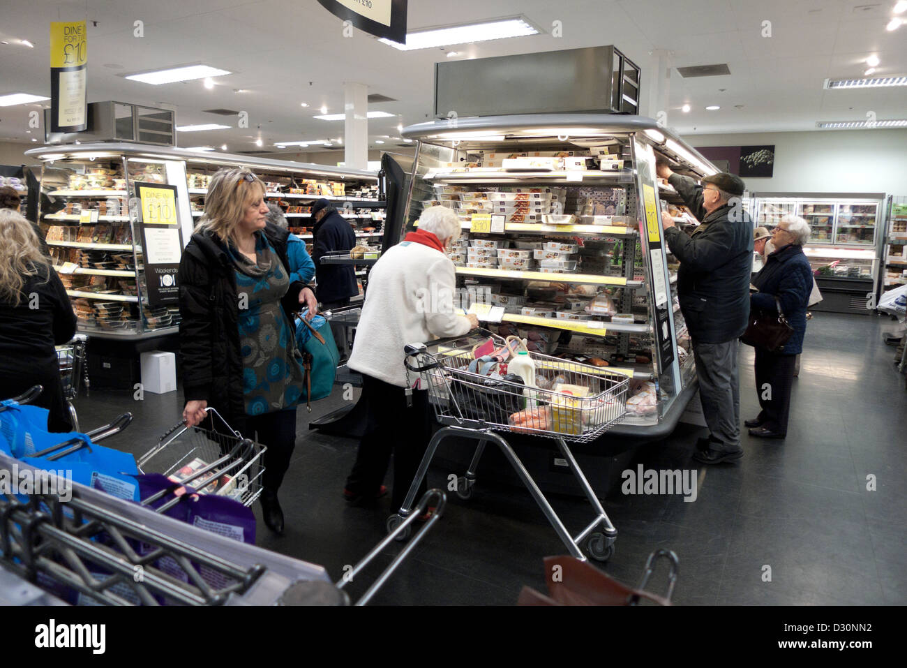 Les clients avec panier et chariot à la recherche sur les produits refroidis à l'allée de réfrigération à l'intérieur magasin Marks and Spencer UK KATHY DEWITT Banque D'Images
