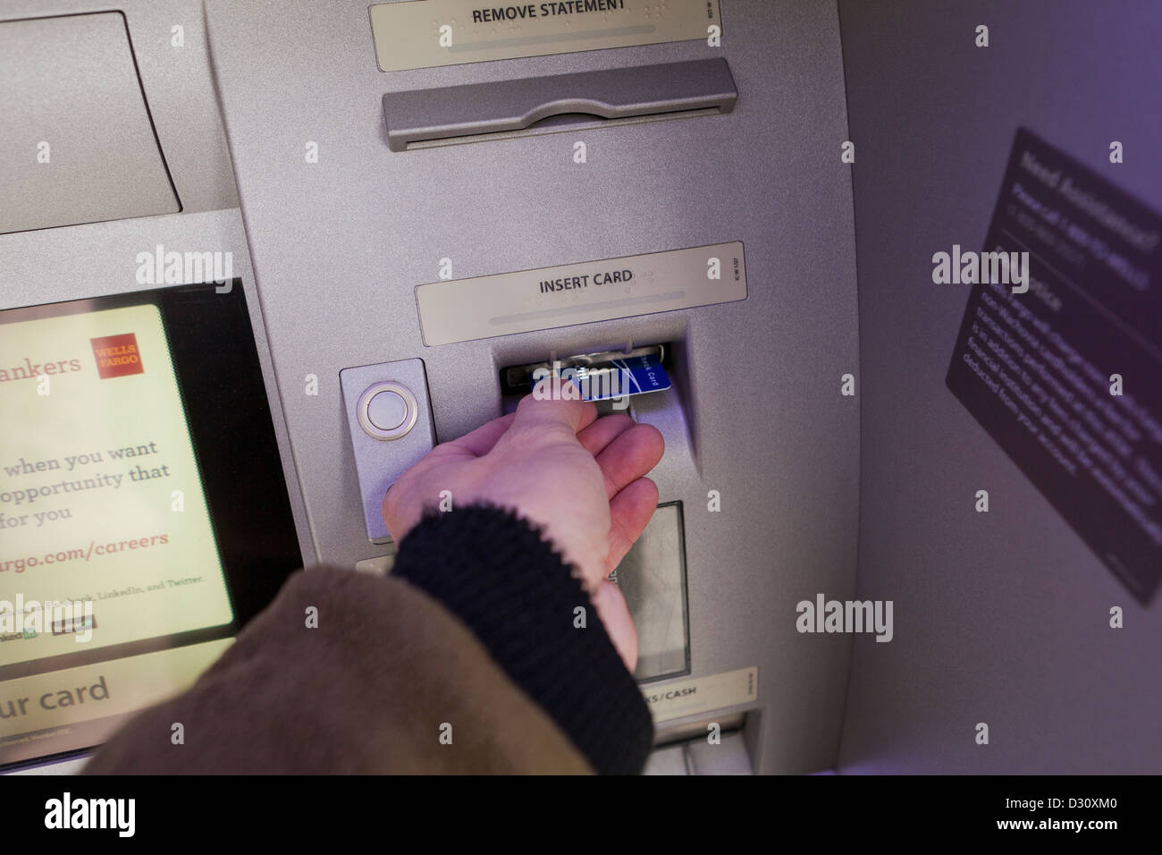 L'homme l'insertion de carte dans un guichet automatique bancaire Banque D'Images