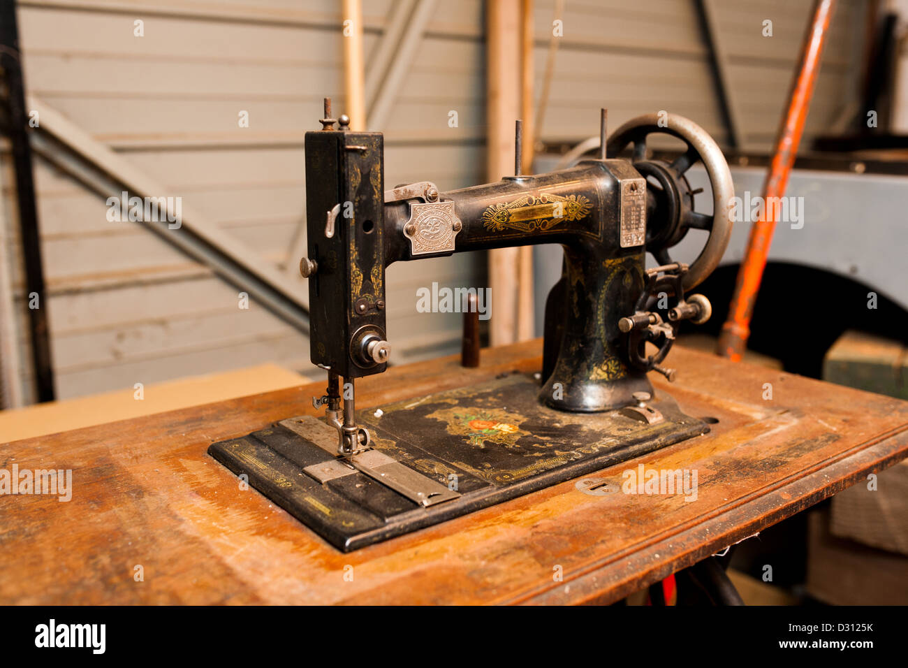 Une vieille machine à coudre vintage, sur une table en bois dans un atelier. Banque D'Images