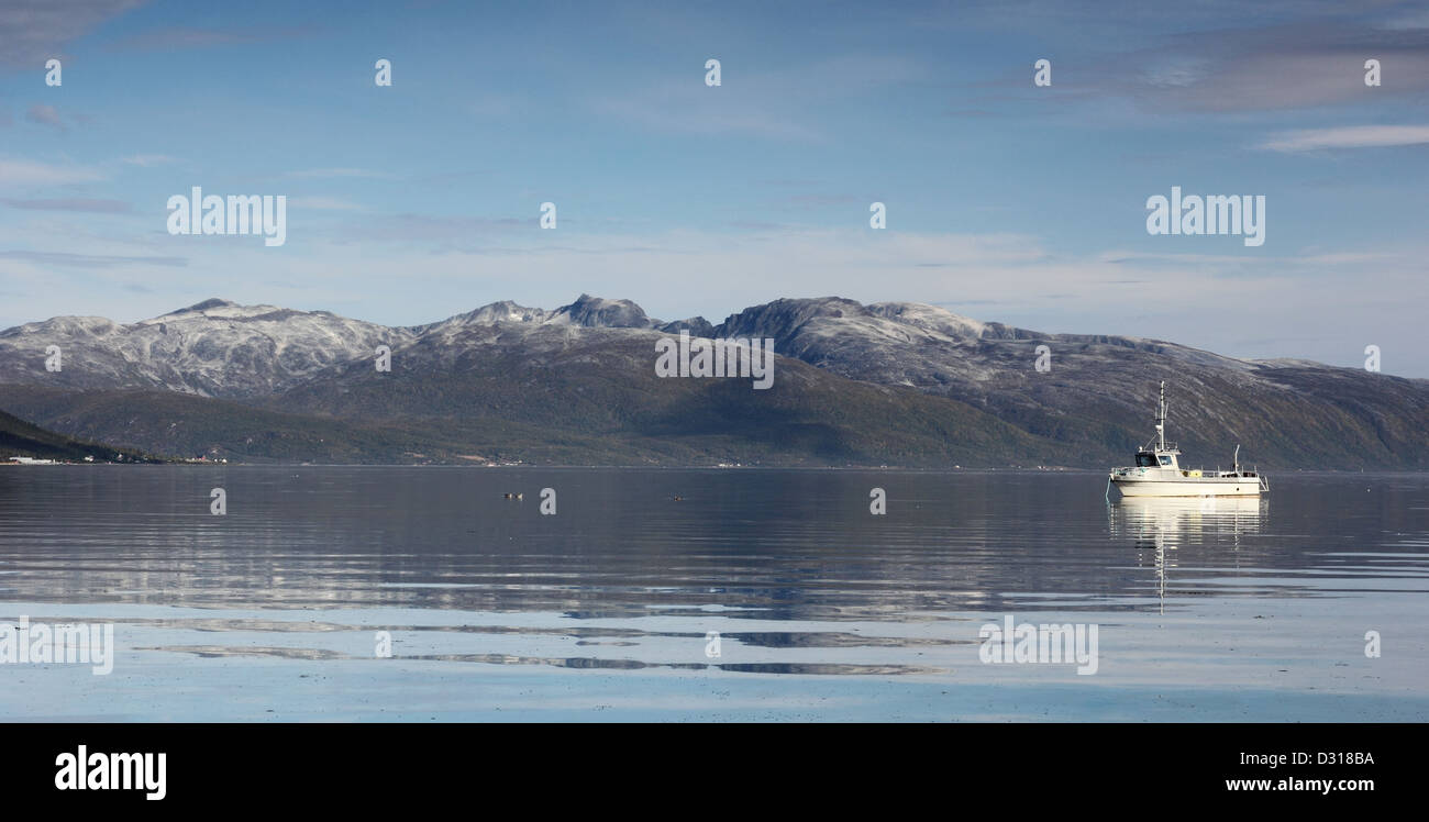Bateau de pêche dans les eaux du fjord calme - le nord de la Norvège Banque D'Images