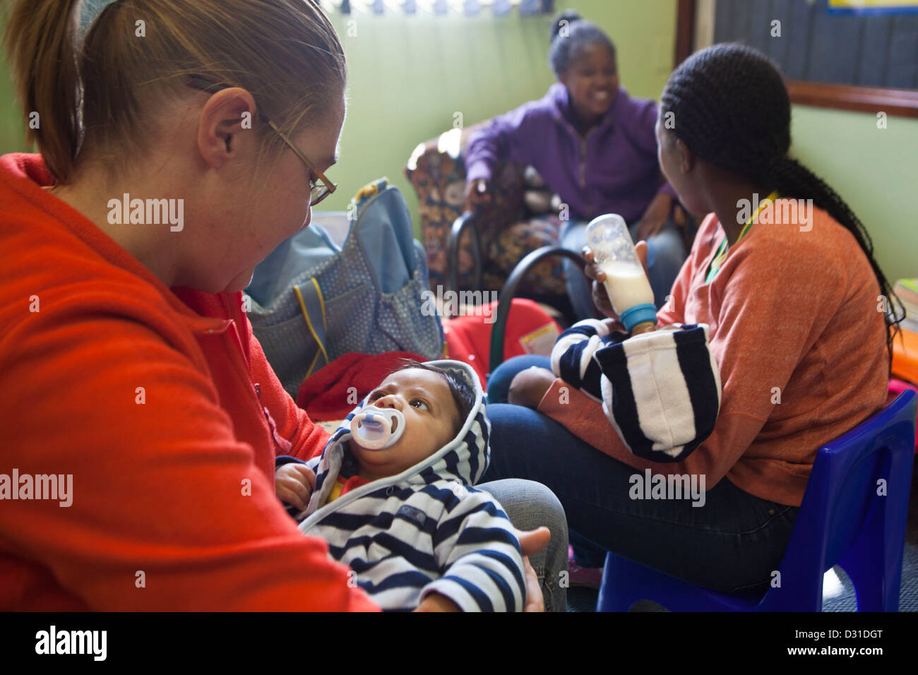 Prendre soin des membres du personnel de sexe féminin, l'interaction et l'alimentation des petits bébés à la Fondation Bigshoes clinique, Johannesburg, Afrique du Sud. Banque D'Images