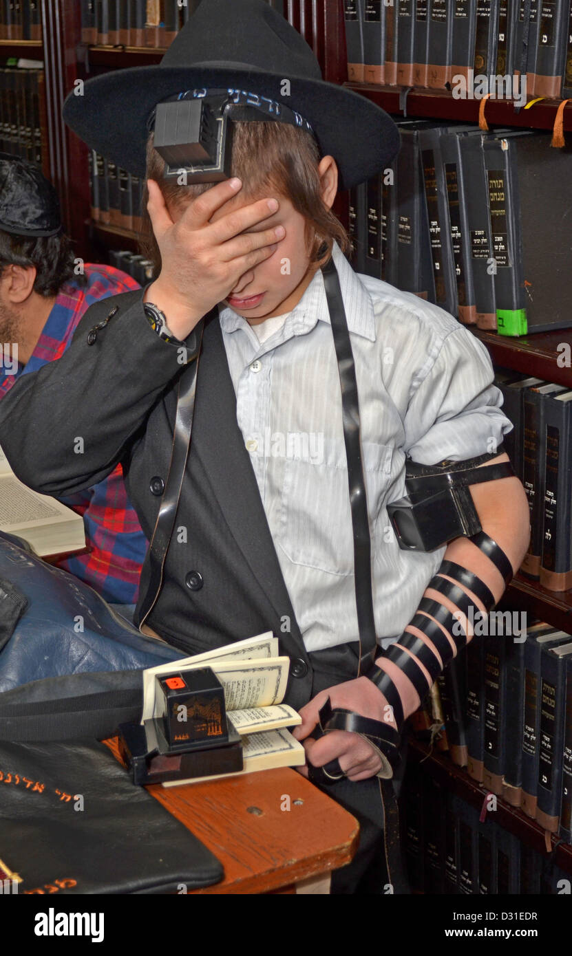 12 ans & 10 mois garçon prie avec phylactères (tefillin) pour la première fois. Au siège de Loubavitch à Brooklyn. Banque D'Images
