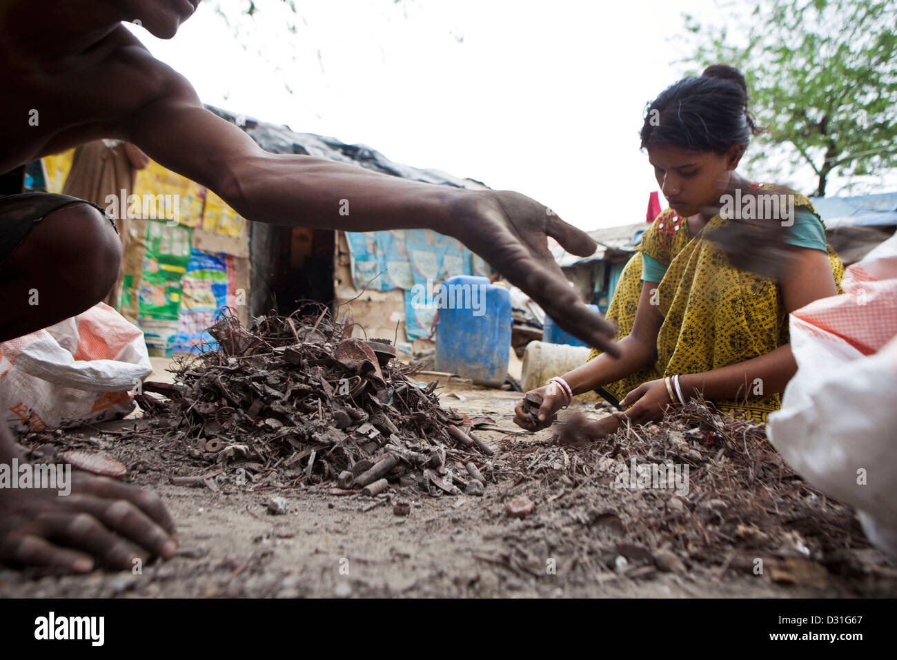 La pauvreté vivant dans Tehkhand Slum, Delhi, Inde. La ferraille recyclage famille trouvés dans la rue pour gagner un peu d'argent. Banque D'Images
