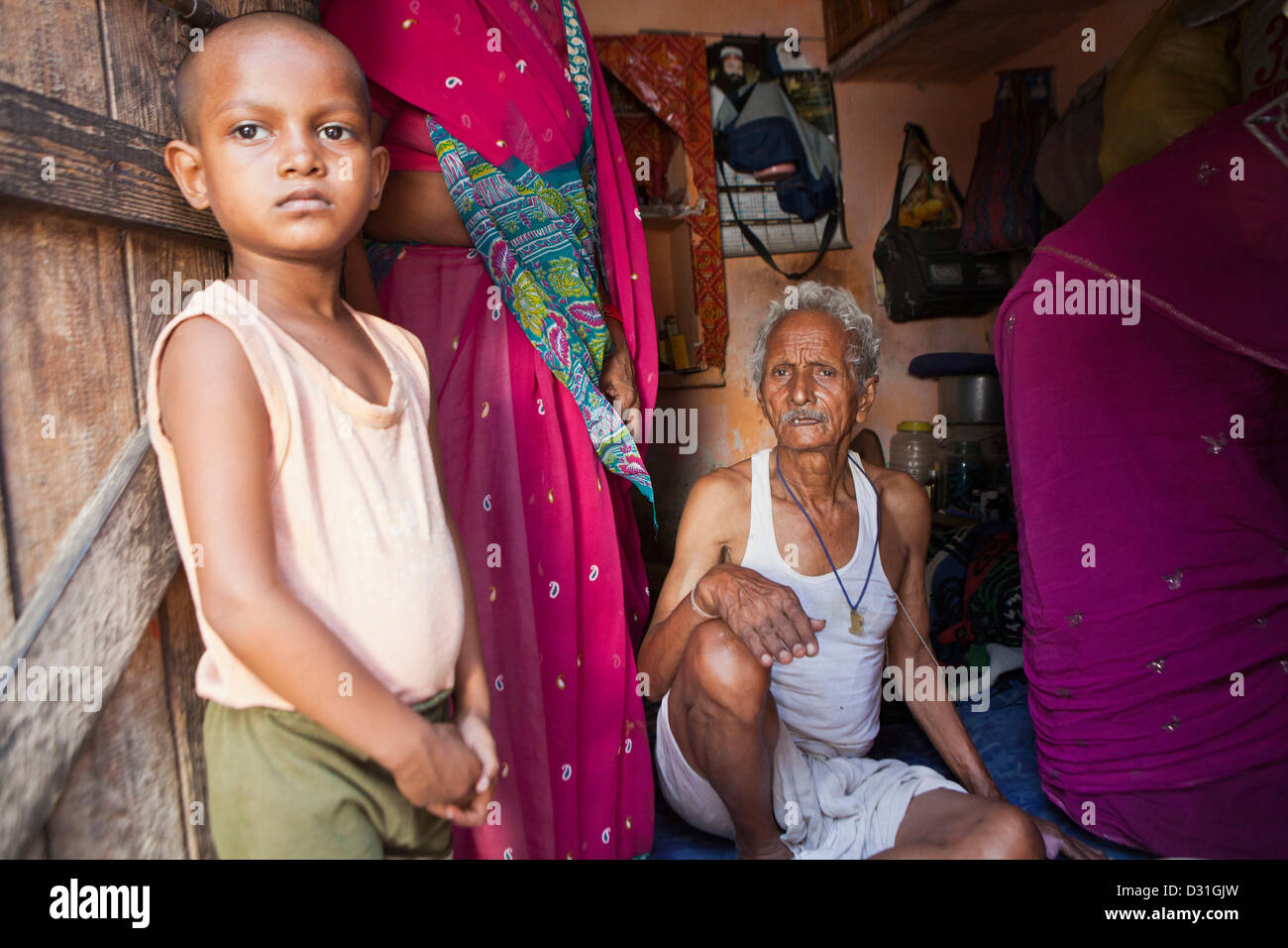 Jeune Indien enfant se tient à la porte de sa maison à Tehkhand Slum, Delhi, Inde. 8 membres de la famille vivent ici. Banque D'Images