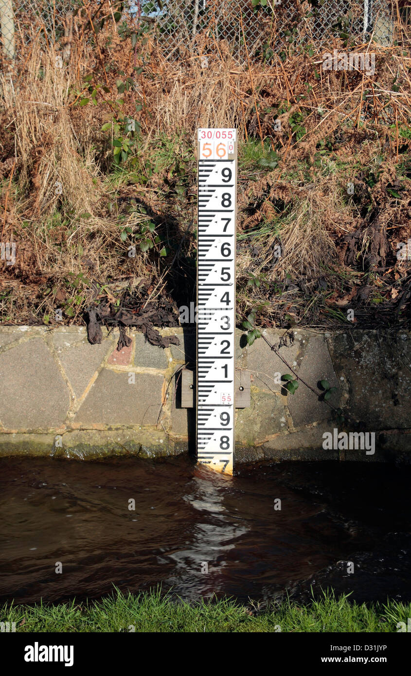 Un côté de la route de l'eau inondation marker (mesure de la profondeur d'un petit canal avec une petite plaine inondable) dans Bagshot, Surrey, UK. Banque D'Images