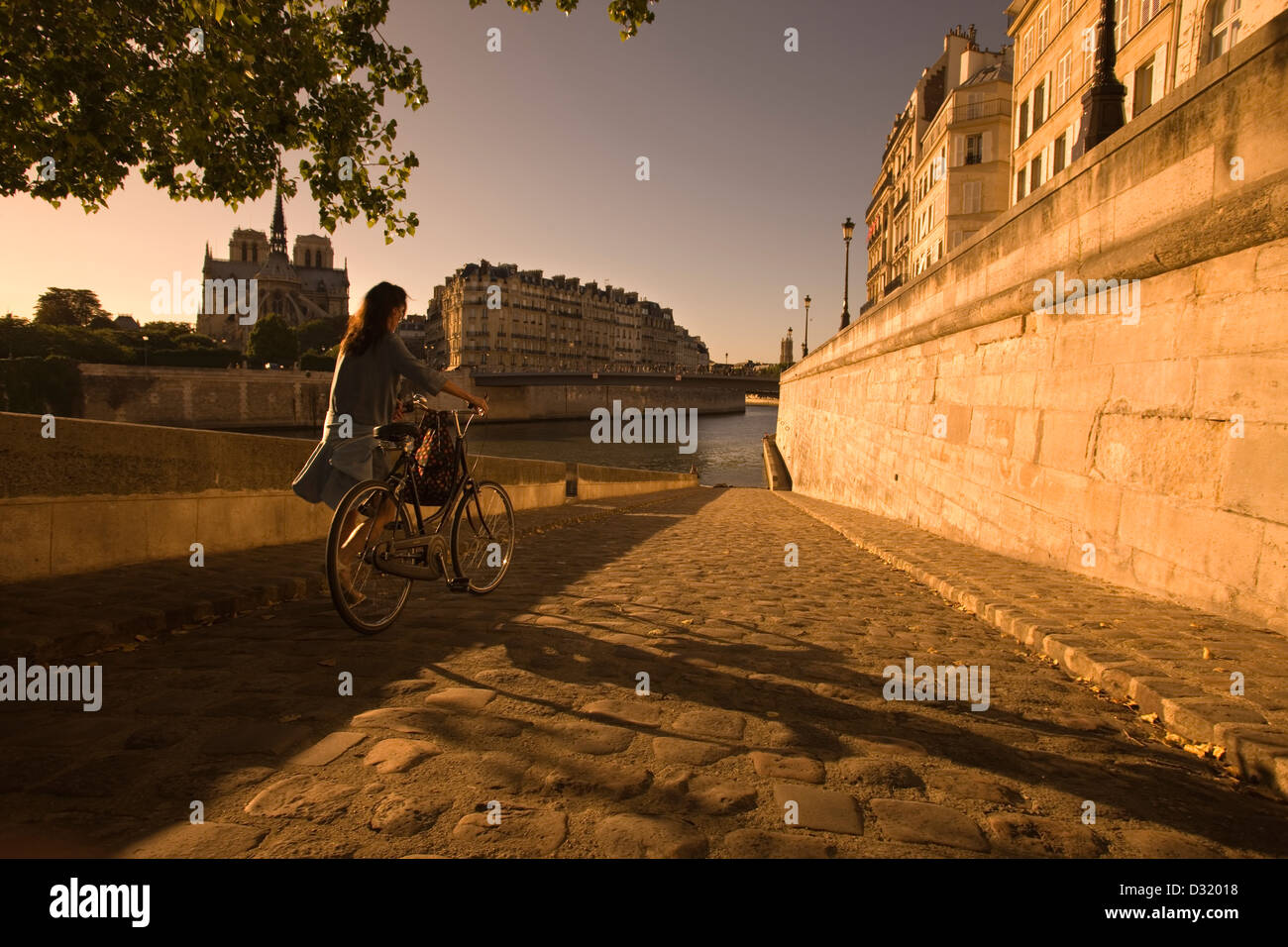 2009 JEUNE FEMME HISTORIQUE POUSSANT VÉLO QUAI DÕORLEANS SEINE ILE SAINT LOUISE PARIS FRANCE Banque D'Images