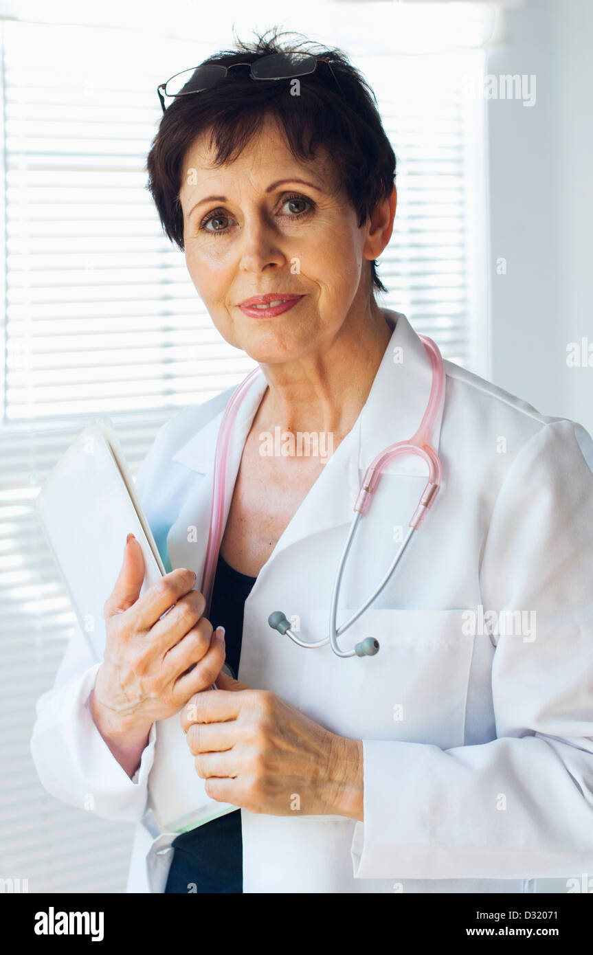 Caucasian doctor holding clipboard in office Banque D'Images