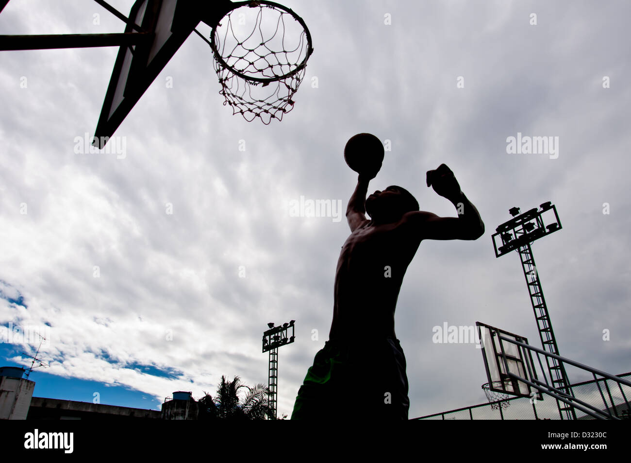 Silhouette de garçon jouant au basket-ball Banque D'Images