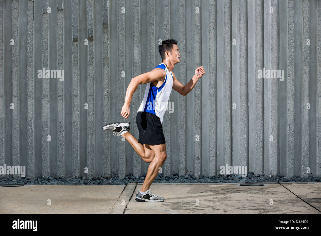 Athlète chinois fonctionnant en milieu urbain ville. Coureur d'Asie en  plein air jogging avec un mur en arrière-plan. Concept de remise en forme  de sexe masculin Photo Stock - Alamy