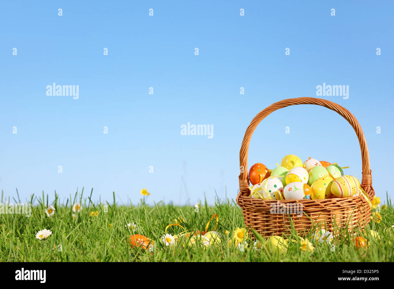 Panier d'oeufs de Pâques sur l'herbe verte à jour ensoleillé. Banque D'Images