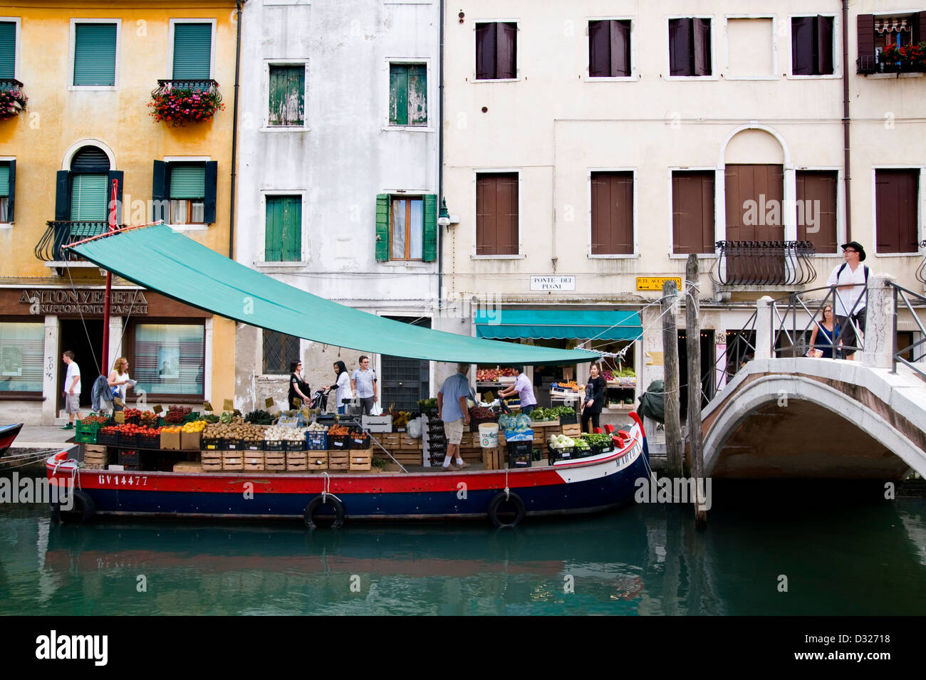 Un vendeur de fruits et légumes sur un bateau sur le Rio de San Barnaba le long de la Fondamenta Girardini et Ponte Dei Pugni, Dorsoduro, Venise, Italie. Banque D'Images