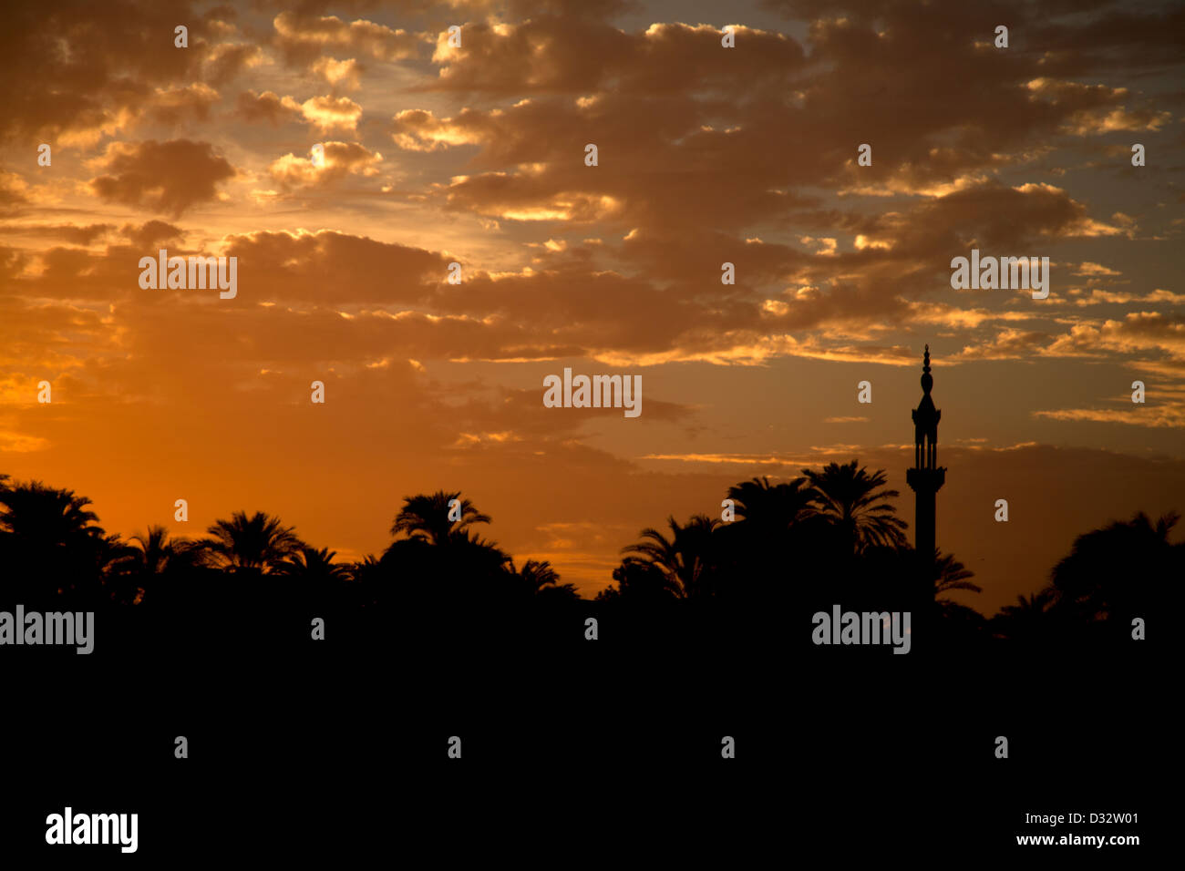 Une mosquée sur le Nil en Egypte silhouetted against a sunset sky Banque D'Images