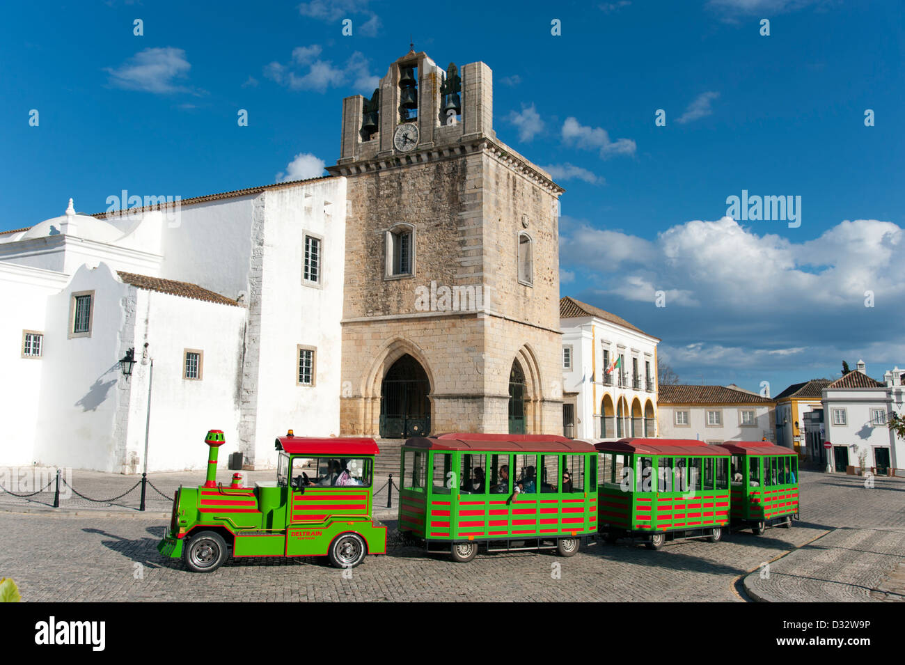 Relations sérieuses in tourisme train passant devant la cathédrale de Faro, Portugal Banque D'Images