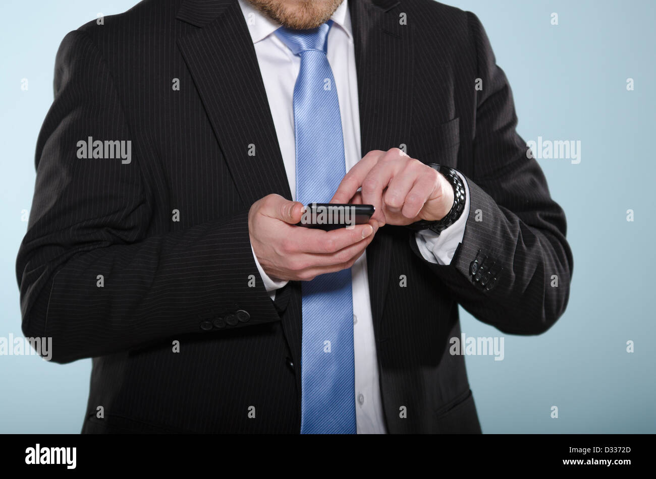 Businessman using smartphone. Section centrale de l'homme adaptée à la légère à l'aide d'un téléphone à écran tactile avec son doigt. Banque D'Images