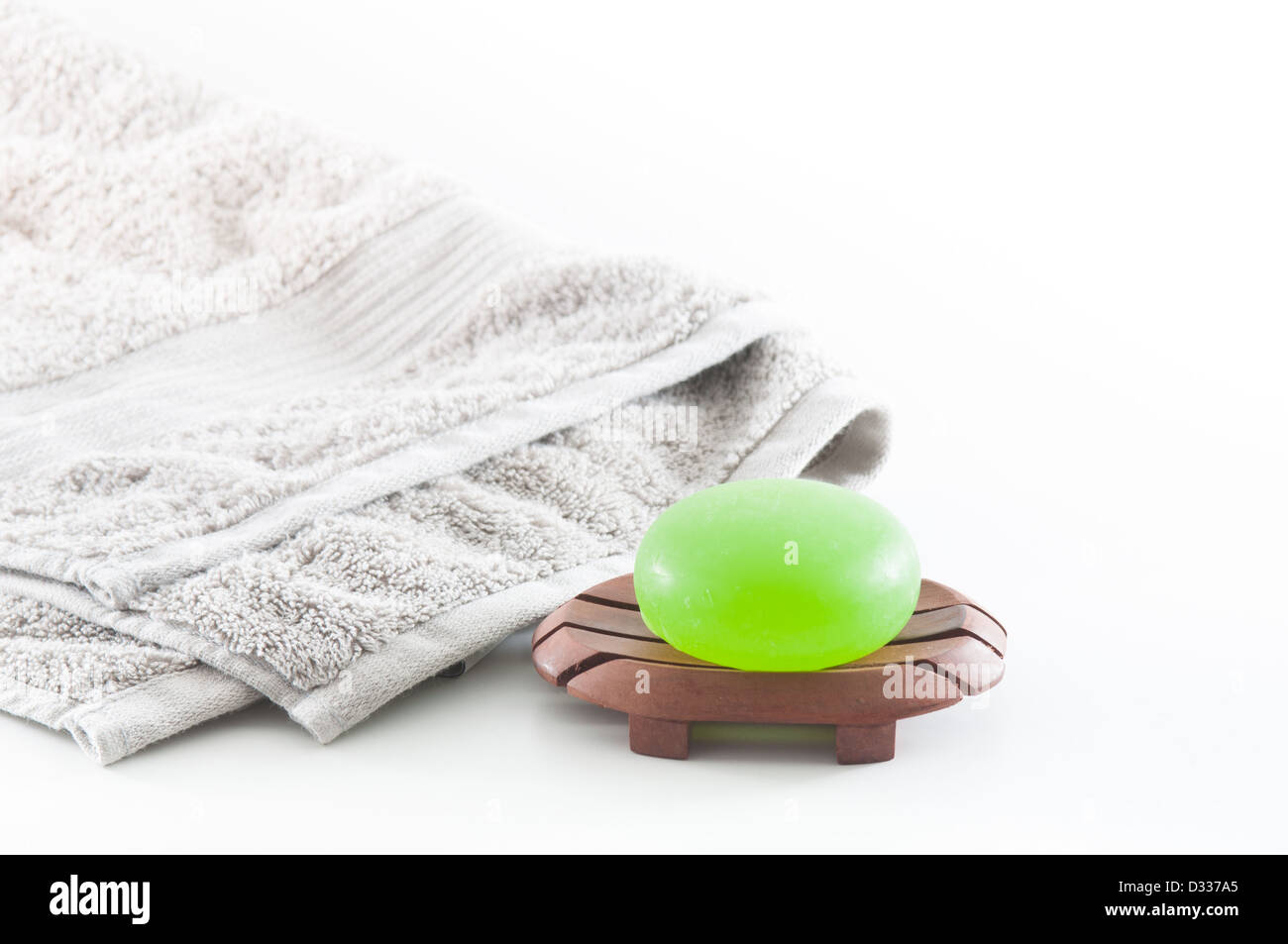 Beau vert profond savon aloe vera sur un fond blanc avec une serviette gris moelleux dans l'arrière-plan Banque D'Images