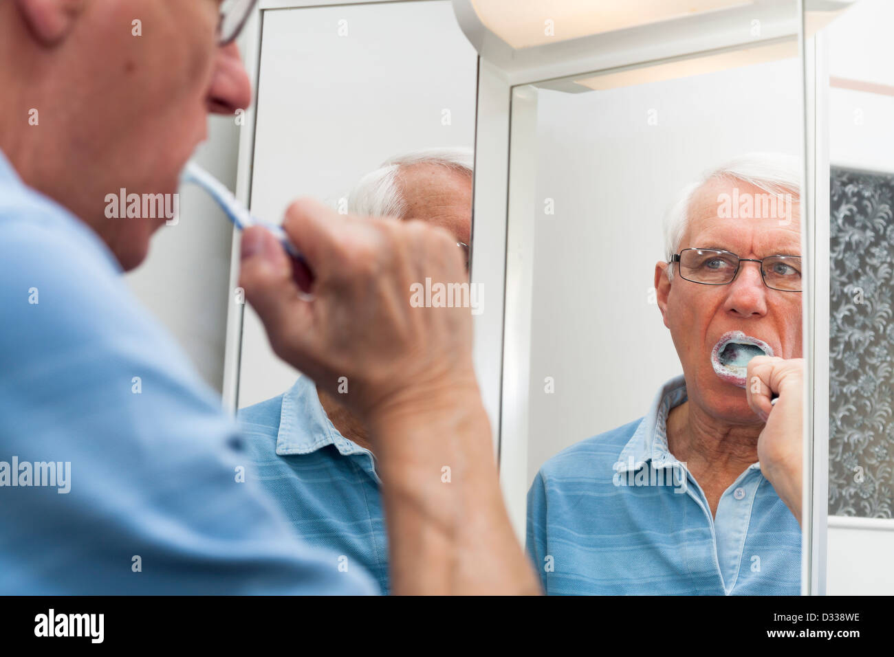 Close up of senior man reflétée dans le miroir se brosser les dents. Banque D'Images