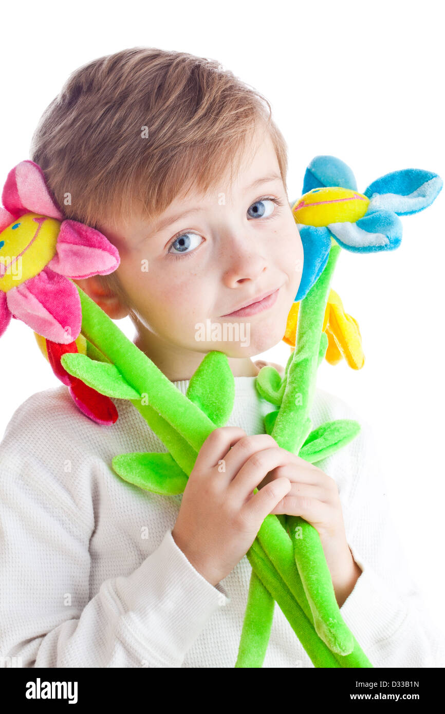 Heureux garçon blond avec des fleurs souriant jouet Banque D'Images