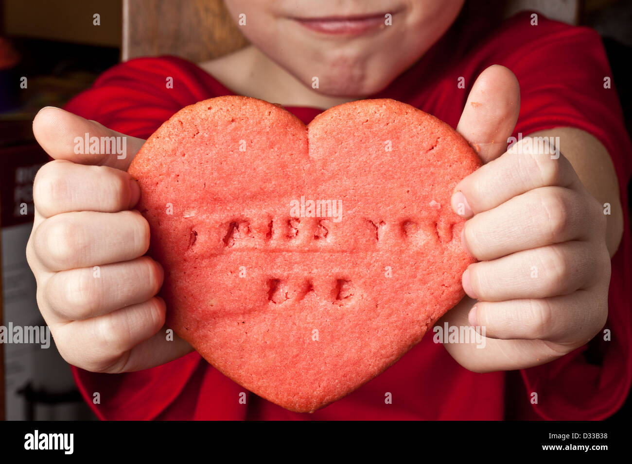 Enfant tient en forme d'coeur cookie avec des mots "I miss you Papa' Banque D'Images