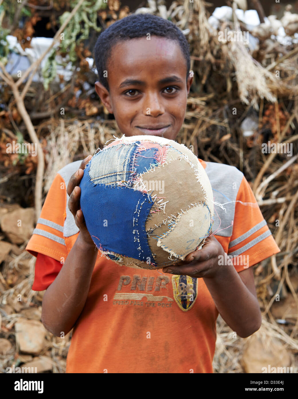 Un enfant tenant un ballon de soccer ou de football Banque D'Images