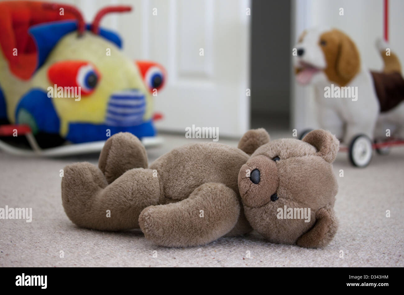 Ours en peluche brun portant sur un plancher de chambre à coucher de l'enfant. Banque D'Images