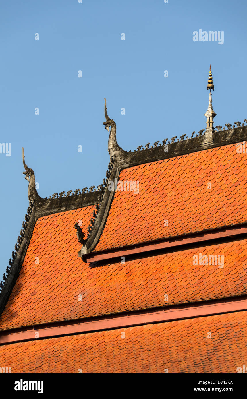 LUANG PRABANG, Laos - l'orange tuiles du toit à plusieurs niveaux de Wat Sensoukharam à Luang Prabang, Laos. Les points du toit sont décorées avec chofah, les représentations de Garuda, le mi-homme mi-oiseau que le dieu hindou Vishnu ride. Banque D'Images