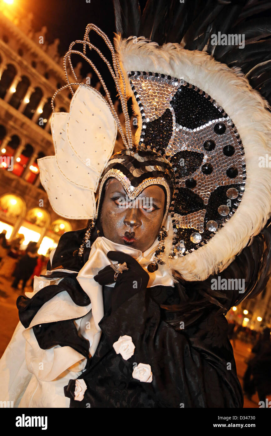 Venise, Italie. 8 février 2013. Comme le soleil commence à définir, les belles personnes du Carnaval de Venise commencent à migrer vers le bord de l'eau dans leurs costumes et masques de poser pour des photos en face de l'île de San Giorgio Maggiore. Le thème pour 2013 est de vivre en couleur. Crédit : Paul Brown / Alamy Live News Banque D'Images