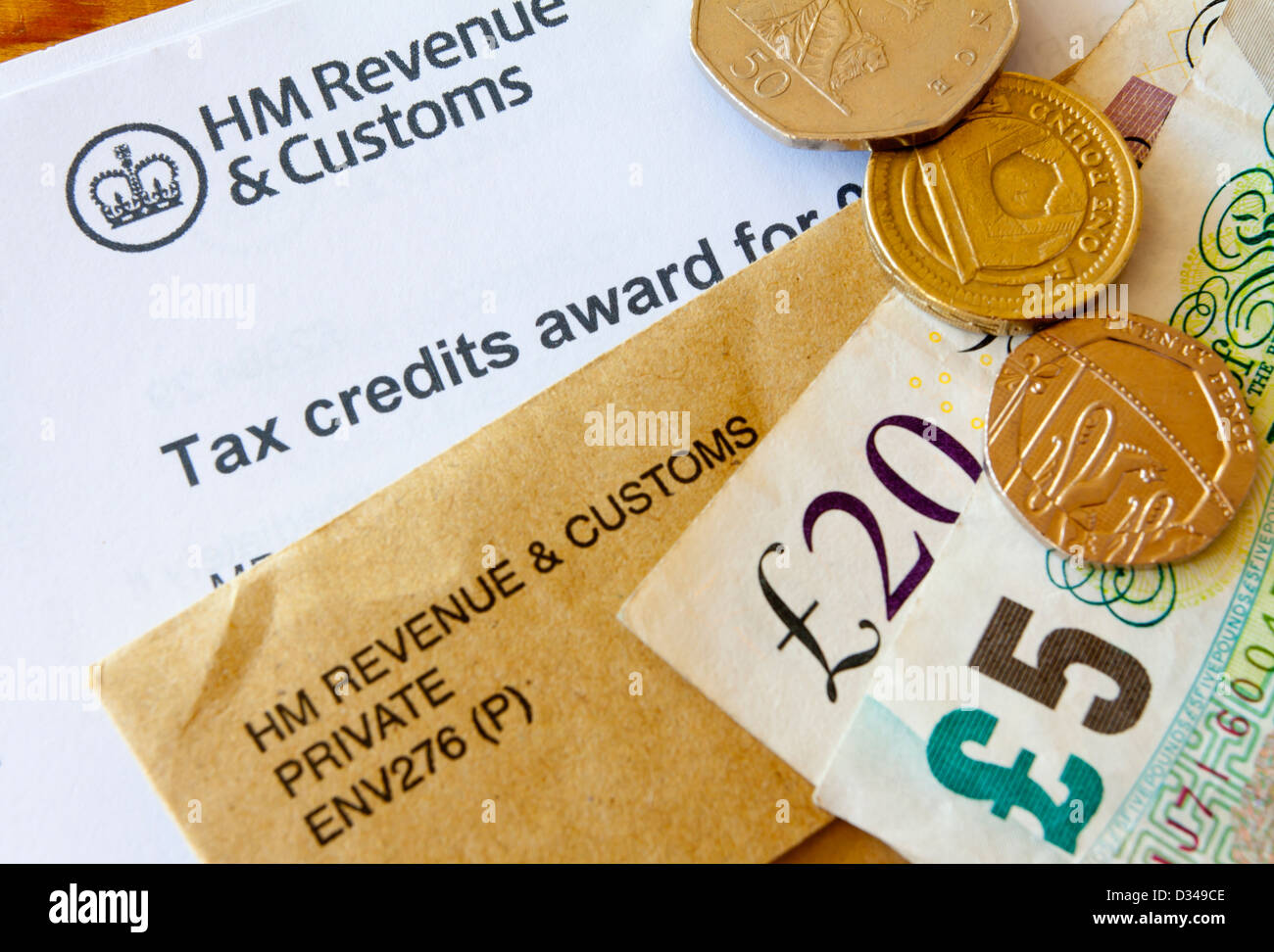 Close up of UK crédits d'award de HM Revenue and Customs avec brown enveloppe officielle et de l'argent en pièces de monnaie et de billets Banque D'Images