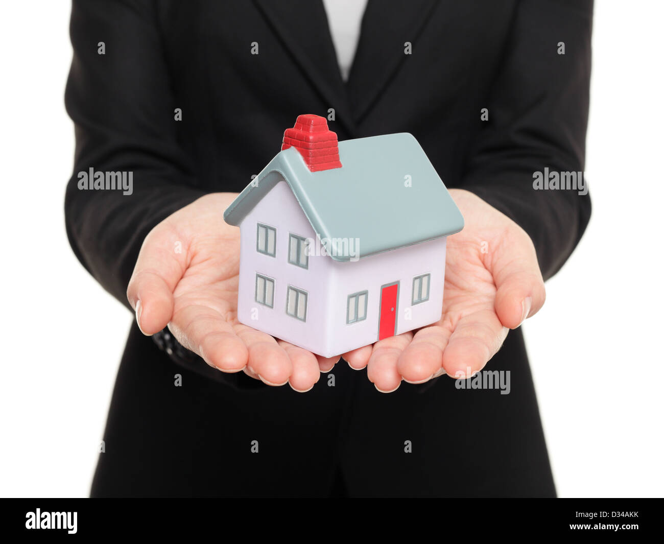 De gros plan femme vrai agent immobilier montrant un mini-maison / home isolé sur fond blanc Banque D'Images
