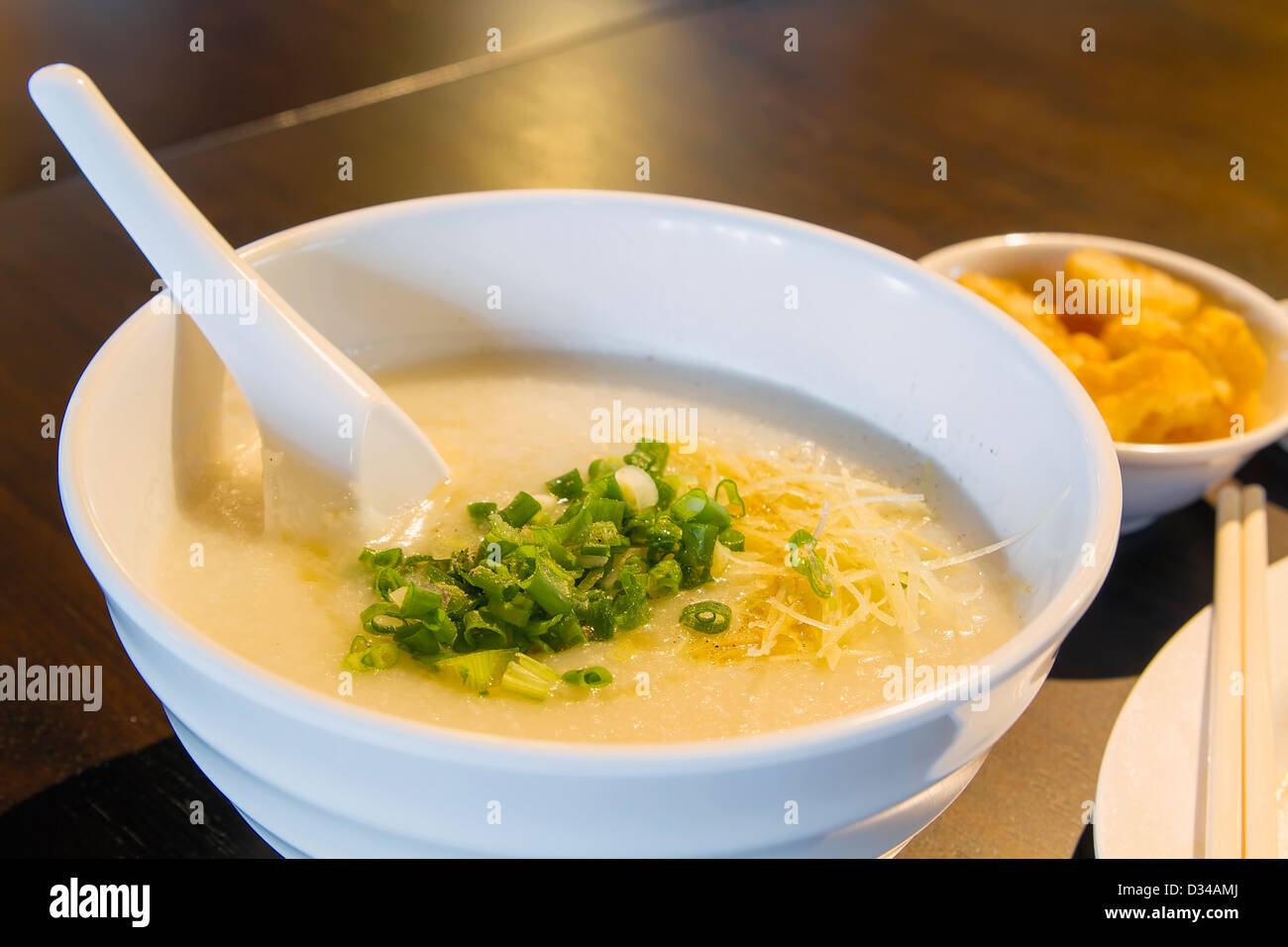 Bol de porridge congee chinois avec les échalotes et le gingembre closeup Banque D'Images