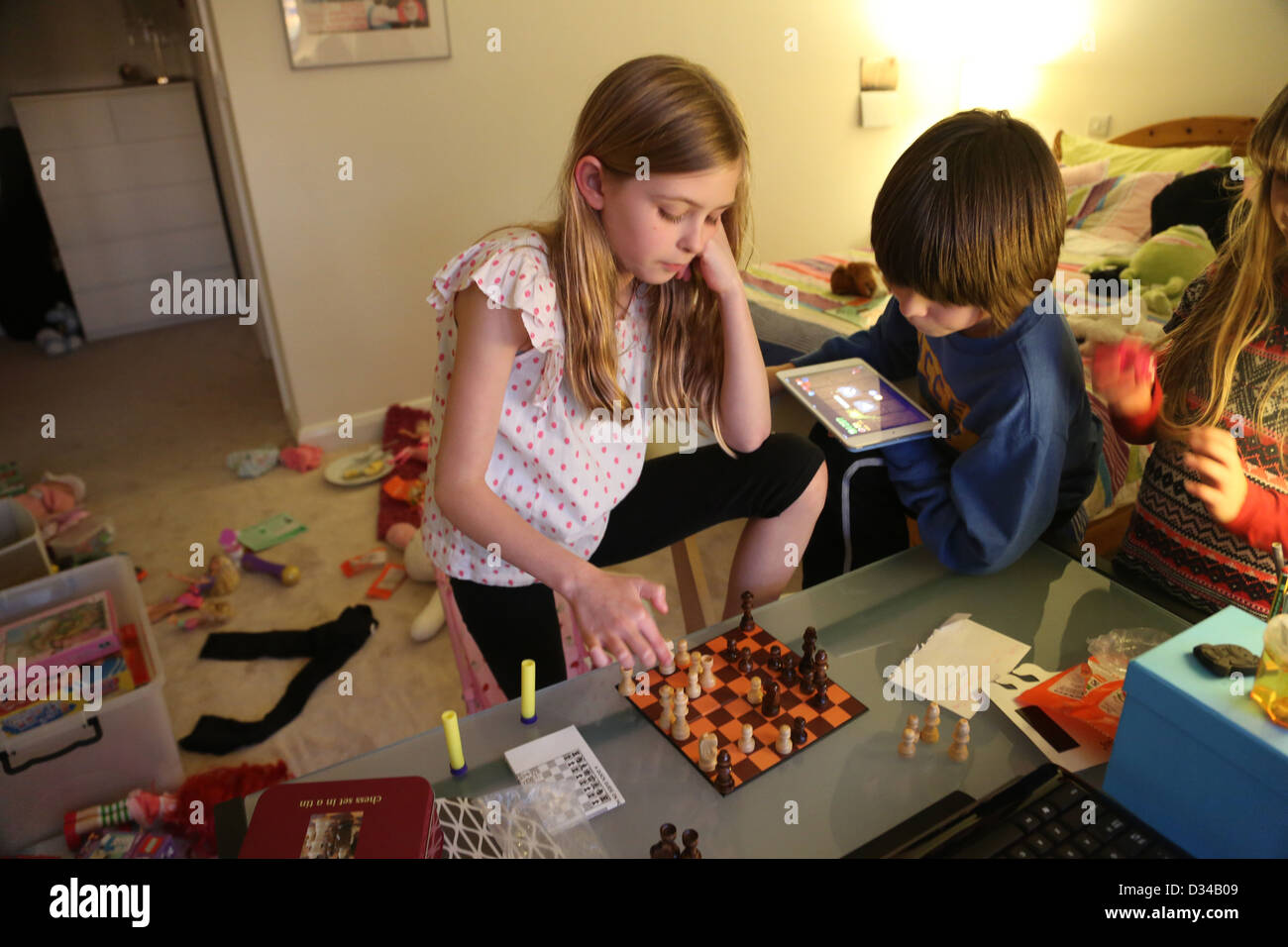 Enfants jouant aux échecs dans leur chambre à coucher Garçon avec iPad Mini en Angleterre Banque D'Images