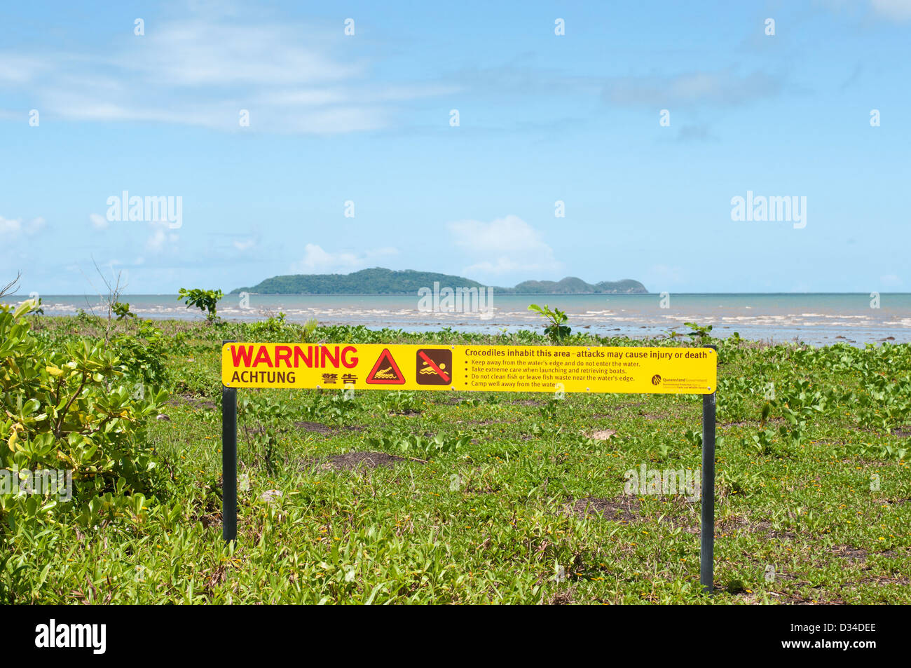 Panneau d'avertissement de crocodile près de la plage à l'embouchure de la rivière Daintree, Snapper Island dans l'arrière-plan, Queensland, Australie Banque D'Images