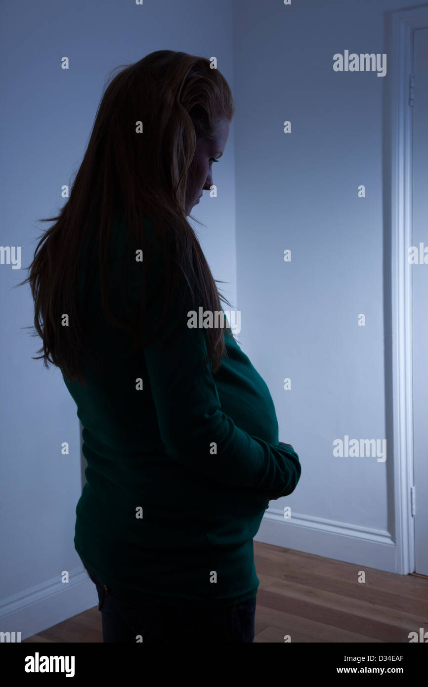 Jeune femme enceinte se profilant à la maison. Banque D'Images