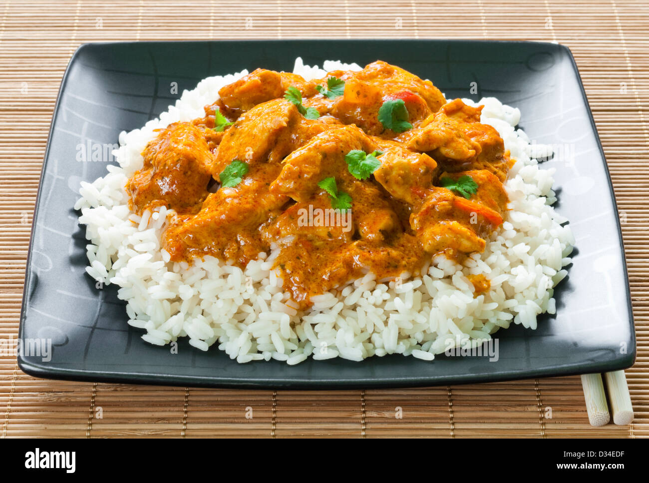 Curry de poulet au riz et baguettes sur place mat Banque D'Images