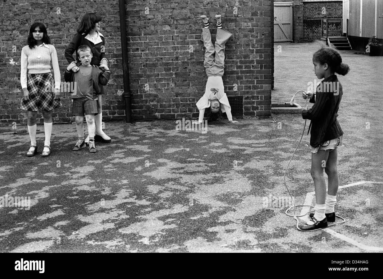 Terrain de jeu de l'école primaire de diversité ethnique. South London 1970s Grande-Bretagne. Les écoliers de BAME. ANGLETERRE 1975 ROYAUME-UNI HOMER SYKES Banque D'Images