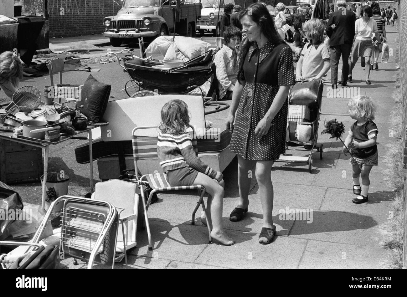 Portobello Road marché du samedi des années 1970 à Londres. C'est à l'extrémité nord qui n'était pas prospère. Les familles ont l'habitude de vendre des choses pour faire les extrémités se rencontrer. Ils ne vendent pas d'antiquités, essentiellement ce sont des gens qui sont dans la pauvreté mais qui essaient de s'en sortir et de fournir à leurs familles des années 70 UK HOMER SYKES Banque D'Images