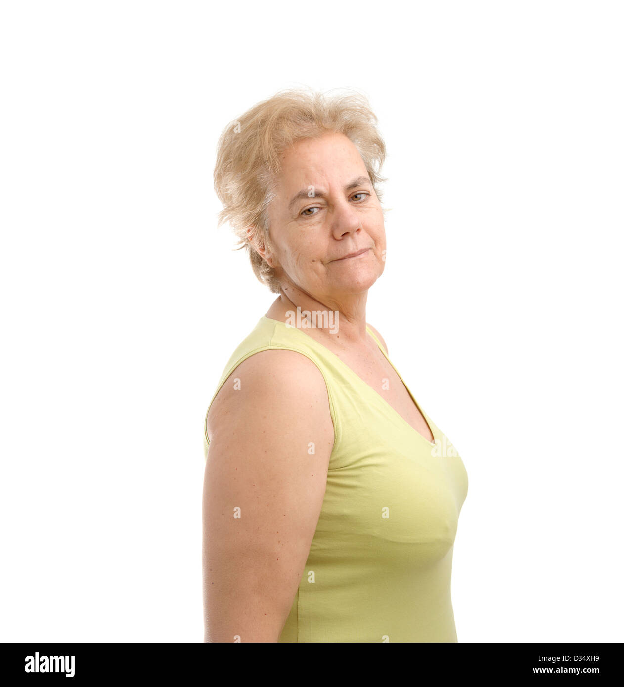 Certain femme d'âge moyen portant un t-shirt vert et regardant par-dessus son épaule droite isolé sur fond blanc Banque D'Images