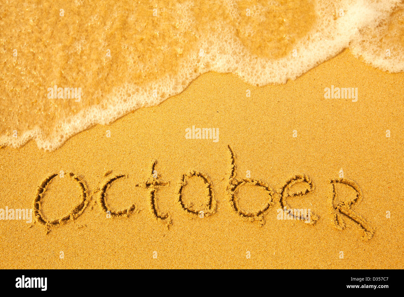 Octobre - écrit dans le sable sur la plage douce texture - vague de la mer (mois année) Banque D'Images