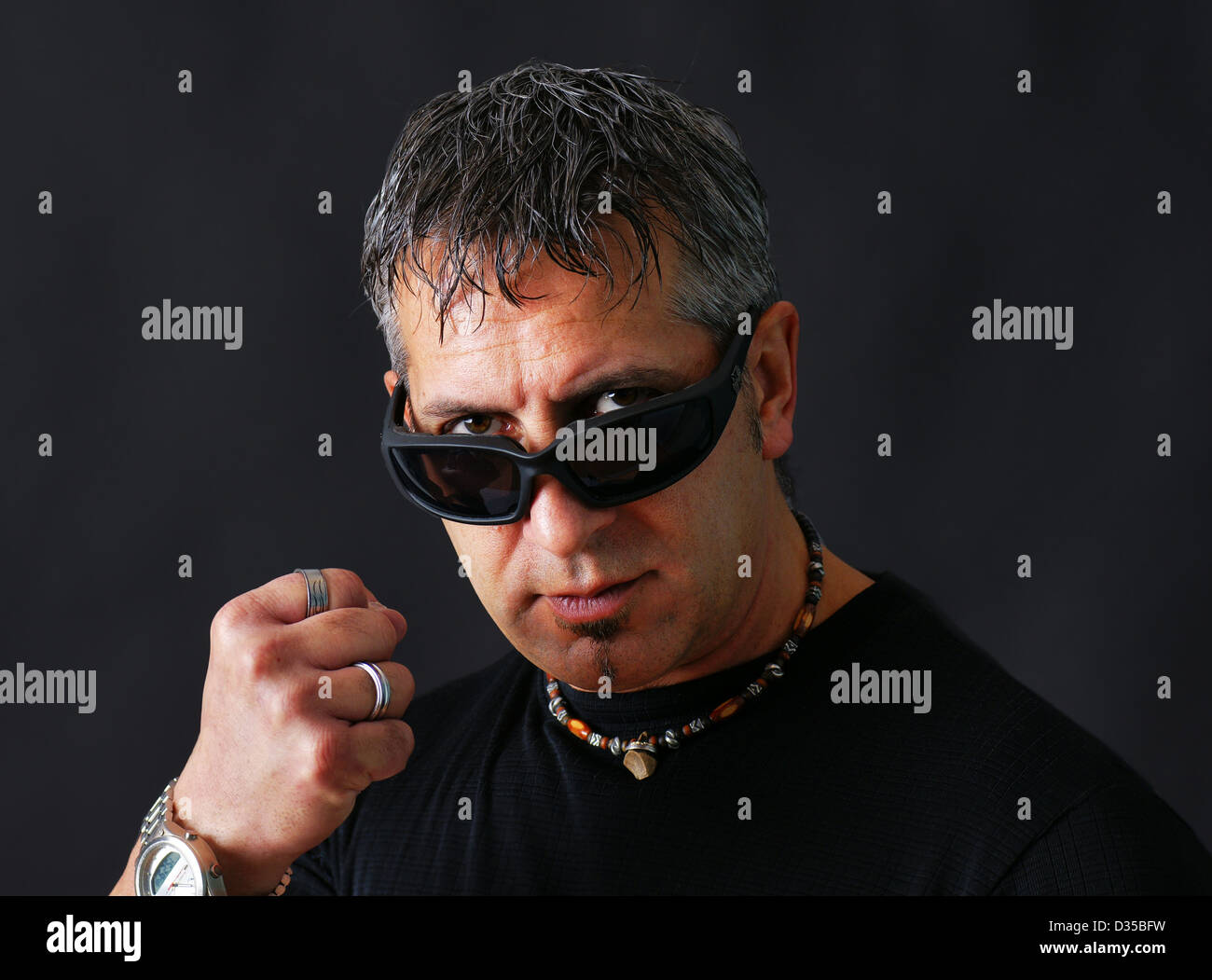 Tough guy en colère ou criminelle avec des lunettes de soleil biker regarder  viewer et le menaçant de son poing fermé Photo Stock - Alamy