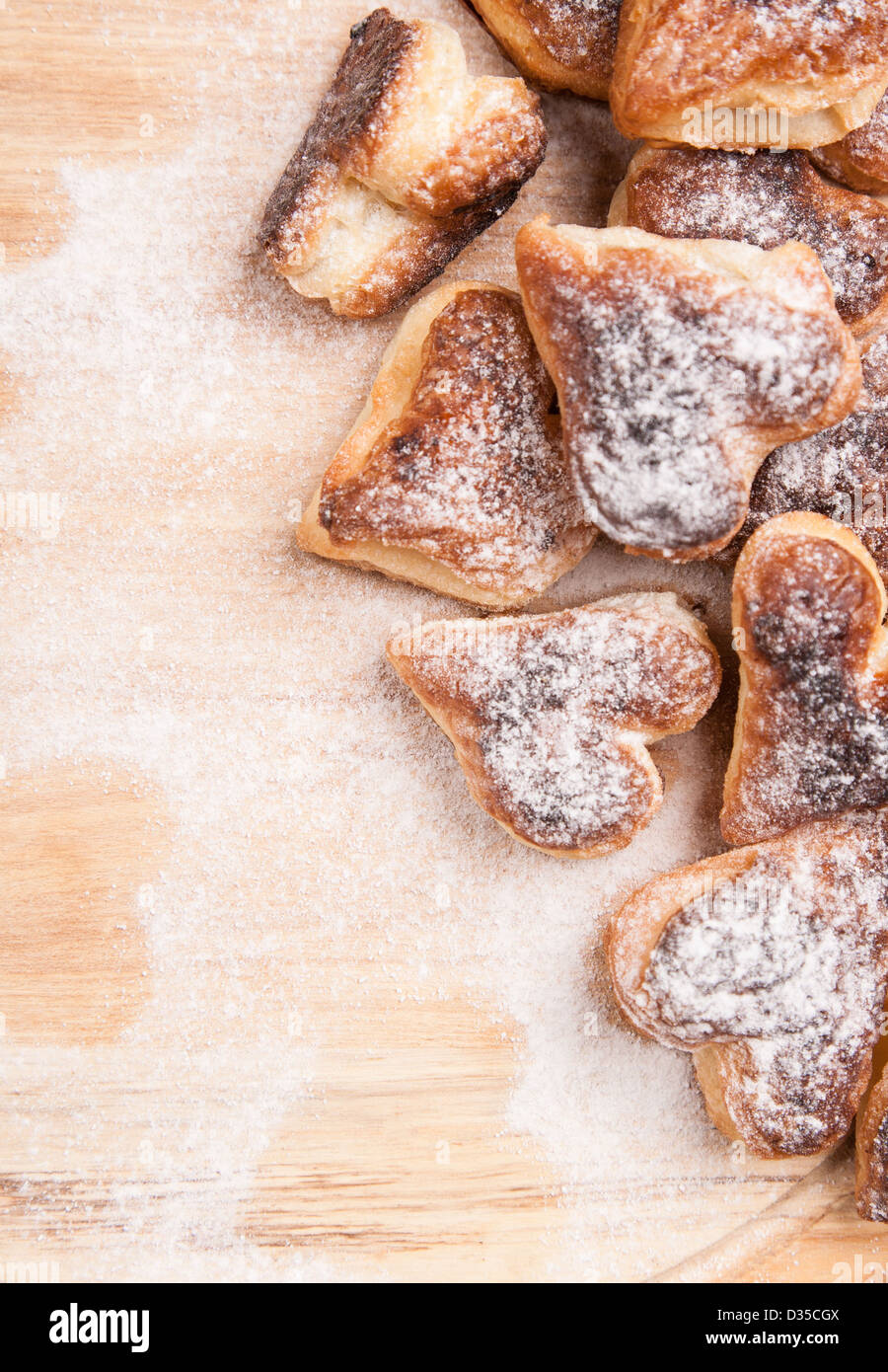 Coeurs boulangerie pâtisserie de split avec du sucre en poudre sur planche de bois Banque D'Images