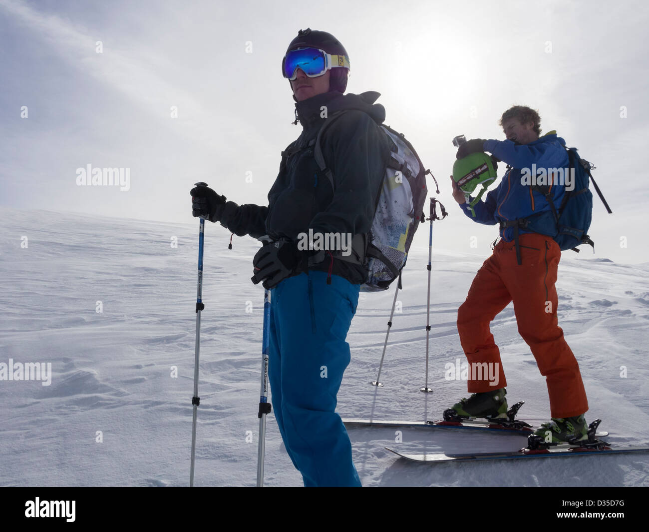 Deux hommes les skieurs en soleil sur des vacances de ski ski sun contre rétroéclairé sur pentes de neige dans les Alpes françaises près de Samoens Rhone-Alpes France Europe Banque D'Images