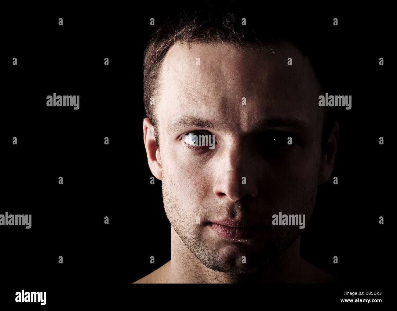 Young Caucasian man's closeup portrait sur fond noir Banque D'Images