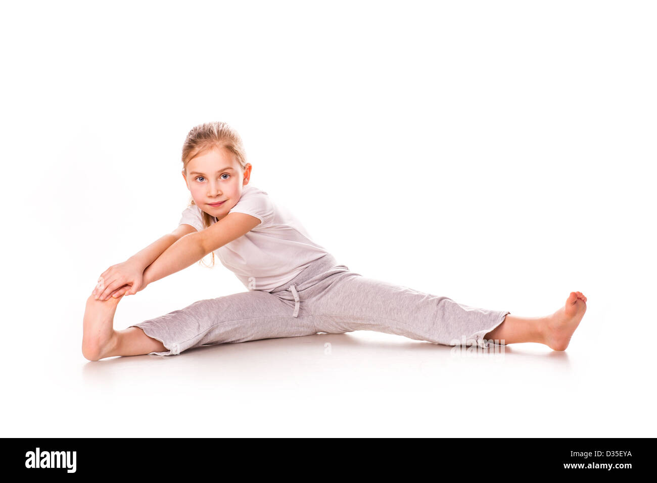 Belle jeune fille gymnaste de l'exercice, l'étirement isolated on white Banque D'Images